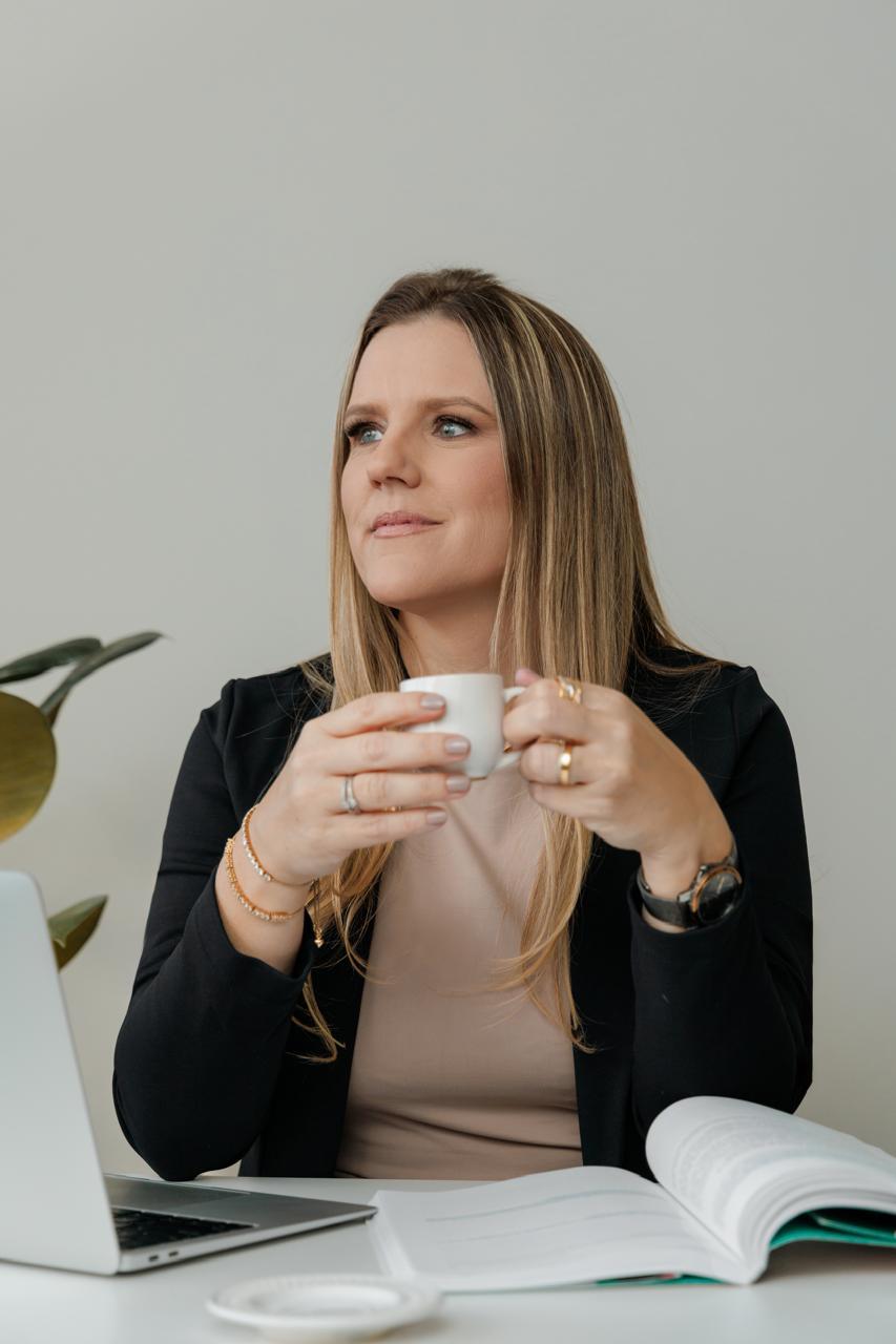 Patrícia Flemming em sessão de atendimento psicológico online, com laptop e caderno em mesa de trabalho